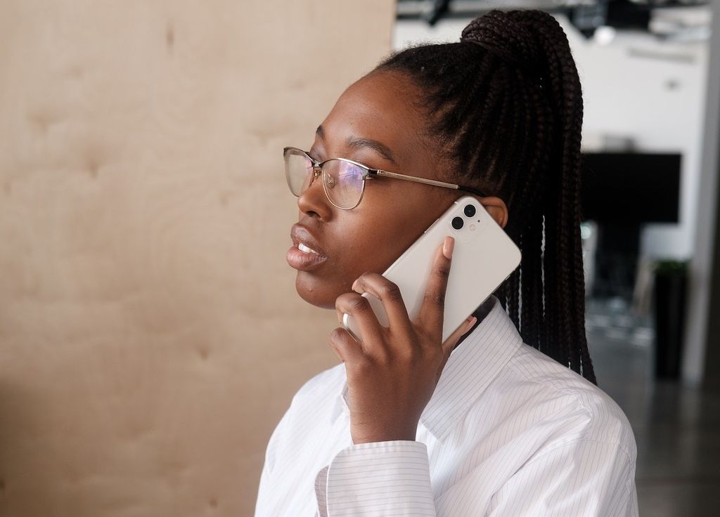 Une femme indépendante a choisi un iPhone reconditionné chez VOO pour le business elle téléphone avec un iPhone Recommerce