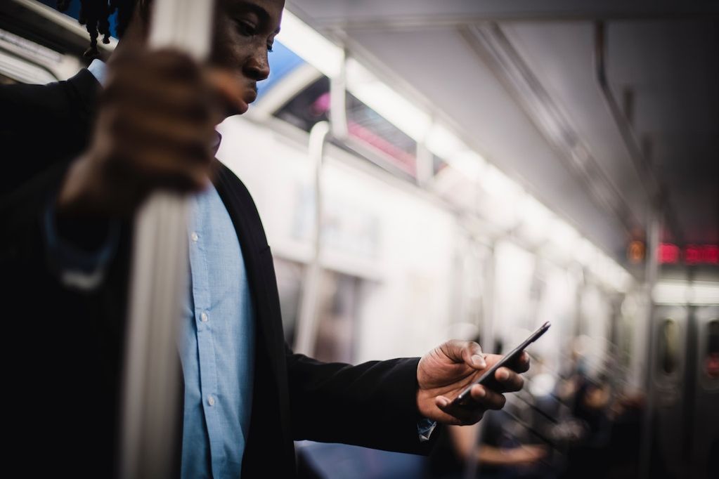 Un homme noir consulte une newsletter dans le métro sur son smartphone à Bruxelles ou à Charleroi