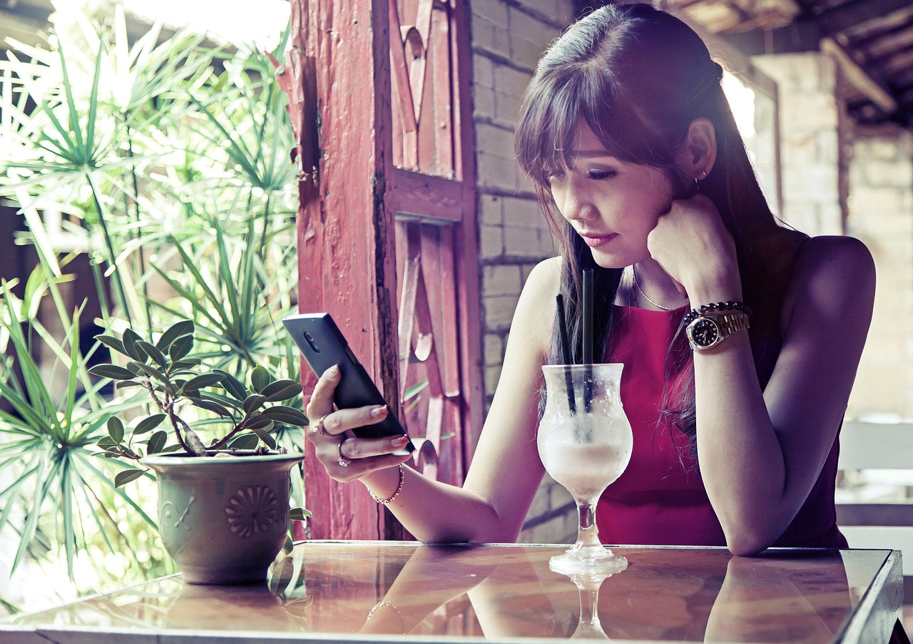 Une fille d'origine asiatique surfe en wifi dans un café restaurant avec VOObusiness