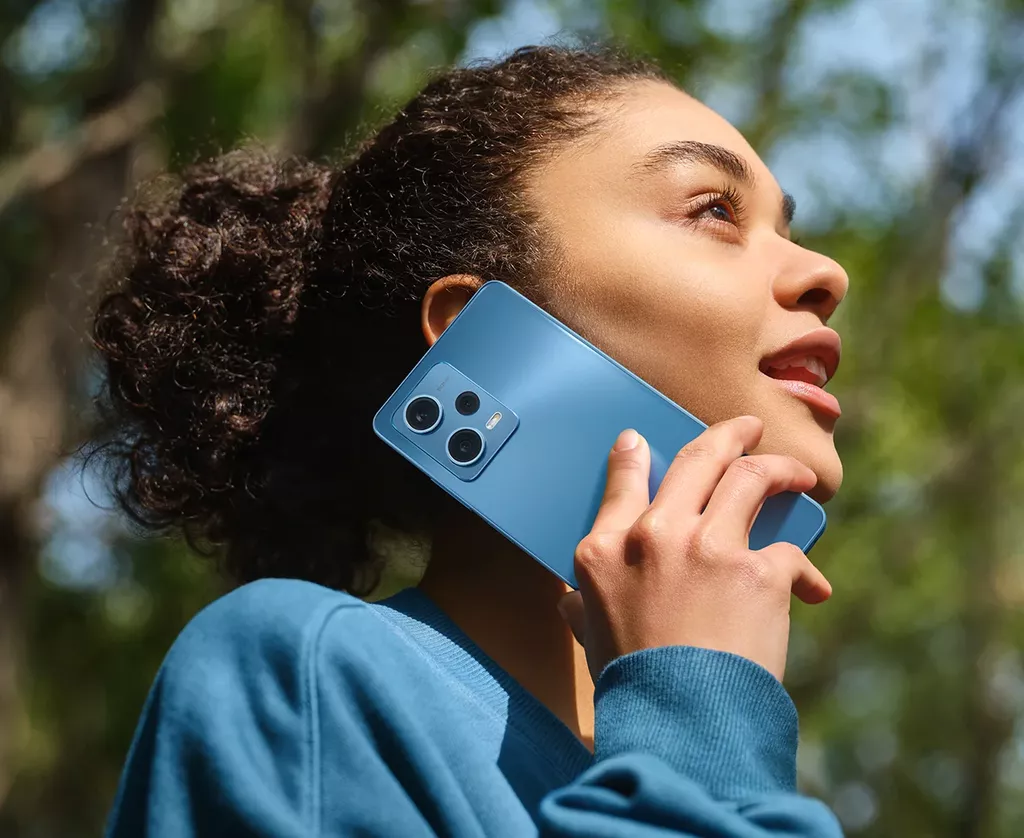 Une fille téléphone avec le modèle bleu du xiaomi redmi note 12 Pro de 2023 acheté en prix promo chez VOO mobile