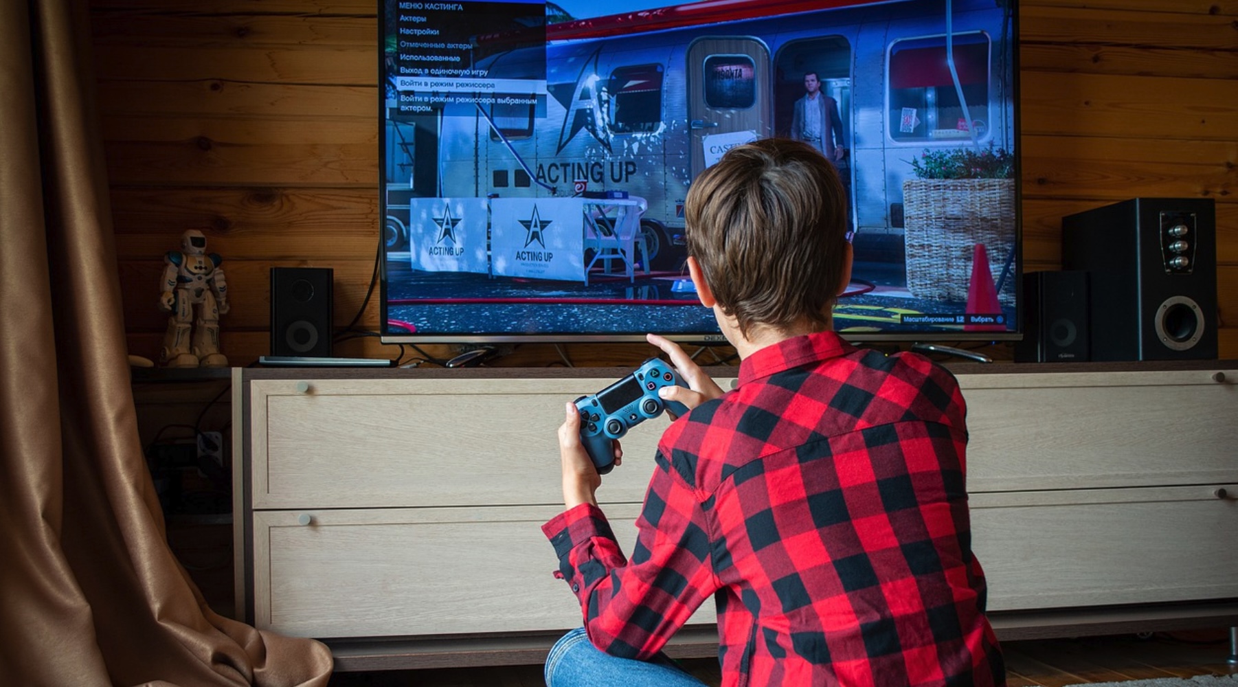 Un garçon joue dans le salon avec une Playstation