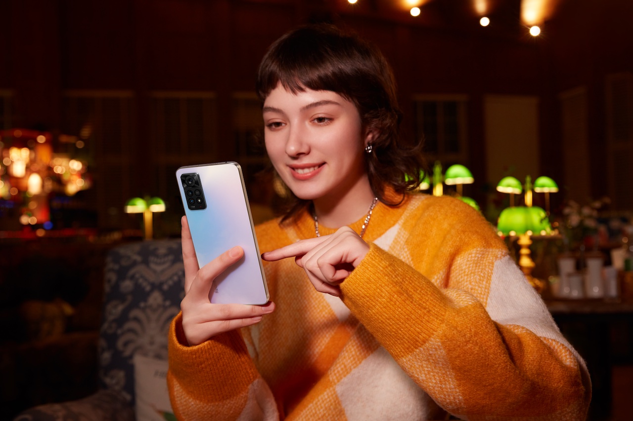 Une femme utilise un Redmi Note 11 de Xiaomi blanc